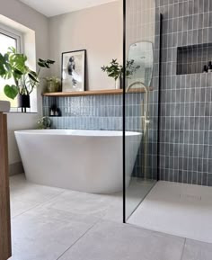 a white bath tub sitting inside of a bathroom next to a window