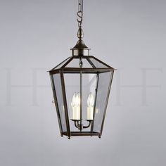 a hanging light fixture with three candles in it