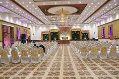 an empty banquet hall with white chairs and yellow sashes on the floor, decorated with lights