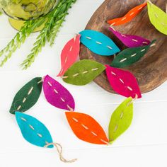 colorful felt leaves are on a wooden plate