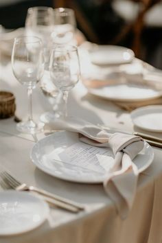 the table is set with white plates and silverware