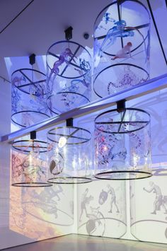 several glass jars with drawings on them hanging from the ceiling