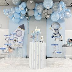 a room filled with blue and silver balloons