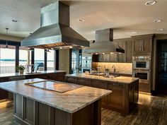 a large kitchen with an island in the middle and two ovens on each side