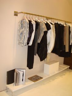 clothes are hanging on a rack in a clothing store