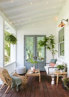 the porch is decorated with wicker furniture and potted plants