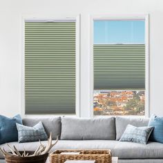 a living room with two large windows covered in blinds