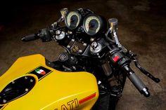 a yellow motorcycle with two gauges on it's handlebars