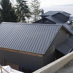 a house with a metal roof next to the ocean