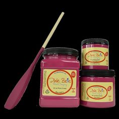 three jars of pink jam with a wooden spoon