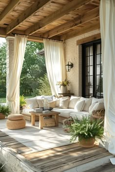 an outdoor living area with couches, tables and potted plants