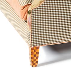 an upholstered couch with checkered fabric and wooden legs