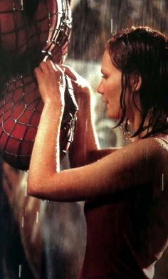 a woman holding a spider man mask in the rain