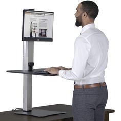 a man standing in front of a computer monitor