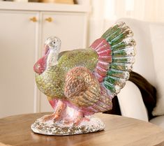 a glass turkey figurine sitting on top of a wooden table in a living room