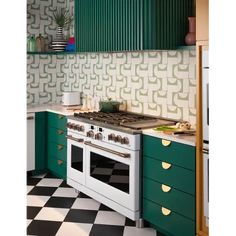 a green and white kitchen with an oven, counter top and checkerboard floor