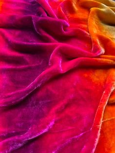 an orange and pink blanket laying on top of each other