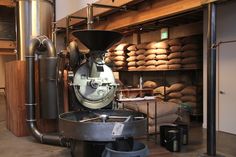 a machine is sitting in the middle of a room filled with barrels and other items