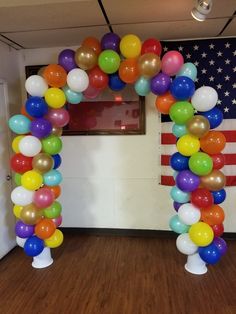 an arch made out of balloons in front of the american flag