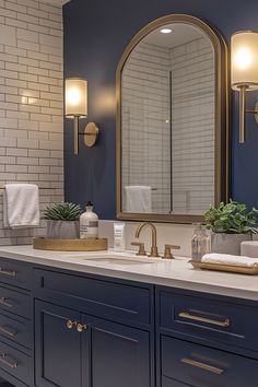 a bathroom with blue cabinets and gold accents