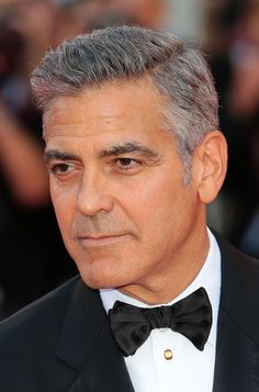 George Clooney’s Short Side Part - George Clooney’s no stranger to looking good, and as we can all see he doesn’t shy away from grey either. Crafting this more distinguished look and adding it to his impeccable repertoire of style, George achieves this by taking the classic “short on the sides, longer on top” haircut and sweeping the top over towards the right side. None of us is perfectly symmetrical, and that’s the true beauty of this style; George can use the sweep of his hair to accent the s Gentleman Haircut, Ivy League Haircut, Haircut Gray Hair, Trendy Mens Hairstyles, Formal Hairstyles For Short Hair, Side Part Haircut, Professional Haircut