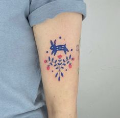 a person with a tattoo on their arm that has an image of a dog and flowers