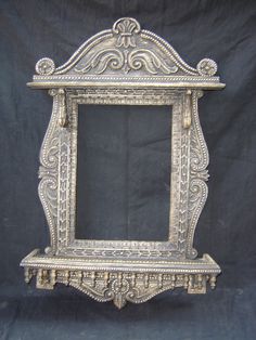 an ornate silver frame on a black background