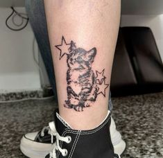 a small tattoo on the leg of a person's foot with stars around it