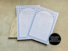 two blue and white checkered baby shower game cards on top of a cork board