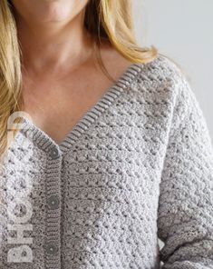 a close up of a woman wearing a sweater with buttons on the front and back