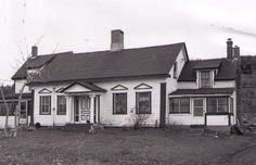 an old photo of a white house in the country