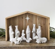 a nativity scene with figurines in the shape of people and animals on a wooden shelf