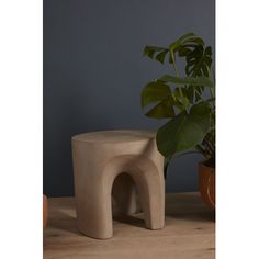 an elephant shaped stool next to a potted plant