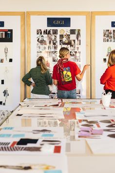 three women are looking at pictures on display