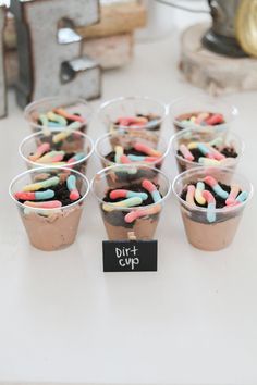 cupcakes with sprinkles are sitting in plastic cups on a table