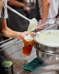 a person is pouring something into a cup