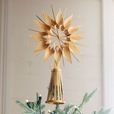 an ornament made out of wooden sticks on top of a christmas tree branch