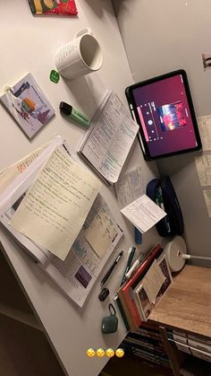 a cluttered desk with books and papers on it