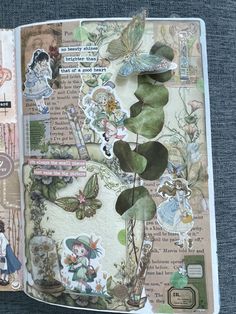 an open book with many stickers on the pages and some plants in it,