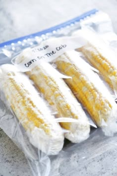 four pieces of corn are wrapped in plastic