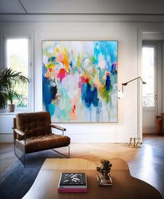 a living room filled with furniture and a painting on the wall