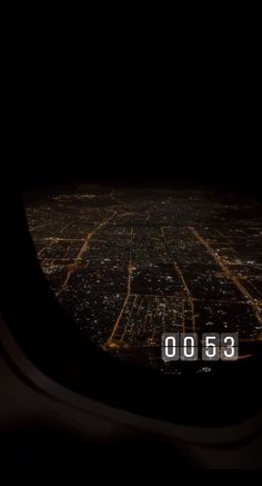 the view from an airplane window at night, looking down on a cityscape