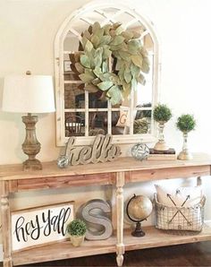 a wooden table topped with a mirror next to a lamp