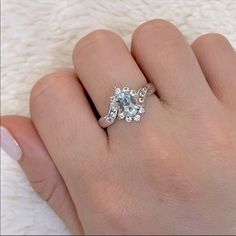 a woman's hand with a ring on it and a diamond in the middle