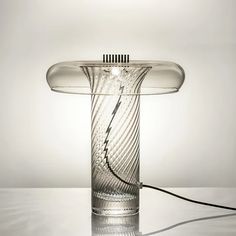 a glass table lamp with a hair dryer plugged into it