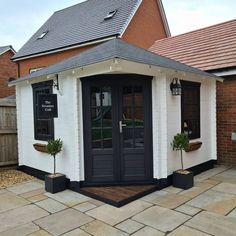 a small white building with black doors and windows