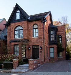 a large brick house with black trim and windows