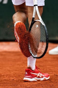 a tennis player with his foot in the dirt