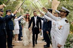 a bride and groom walking down a path with their arms in the air as confetti is thrown around them