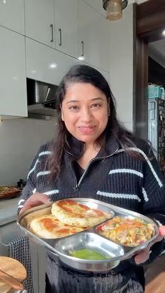 a woman holding a tray of food in her hands